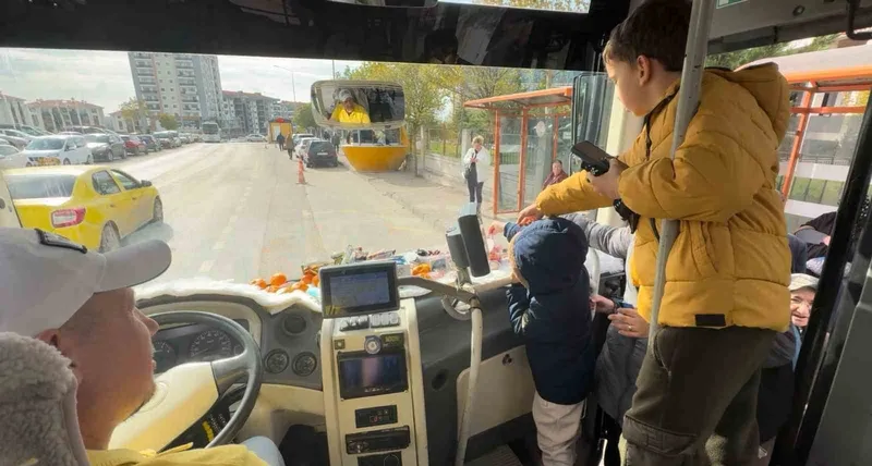 Şoför minibüse binen yolcularına meyve ve şekerleme ikram ediyor
