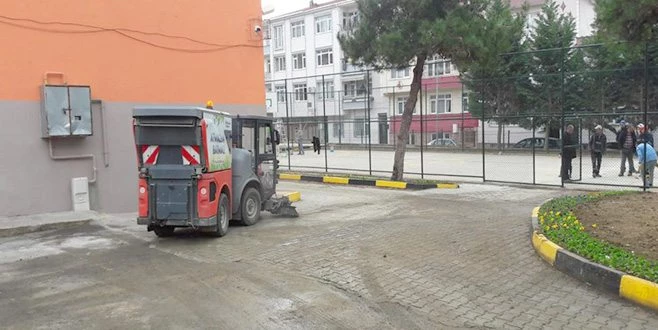 OKUL BAHÇELERİNİN DE TEMİZLİĞİNİ YAPIYOR